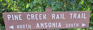 Pine Creek Rail Trail sign indicating North and South