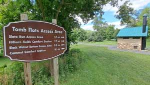 Tomb Flats access are is a large area with grass, trees and water.
